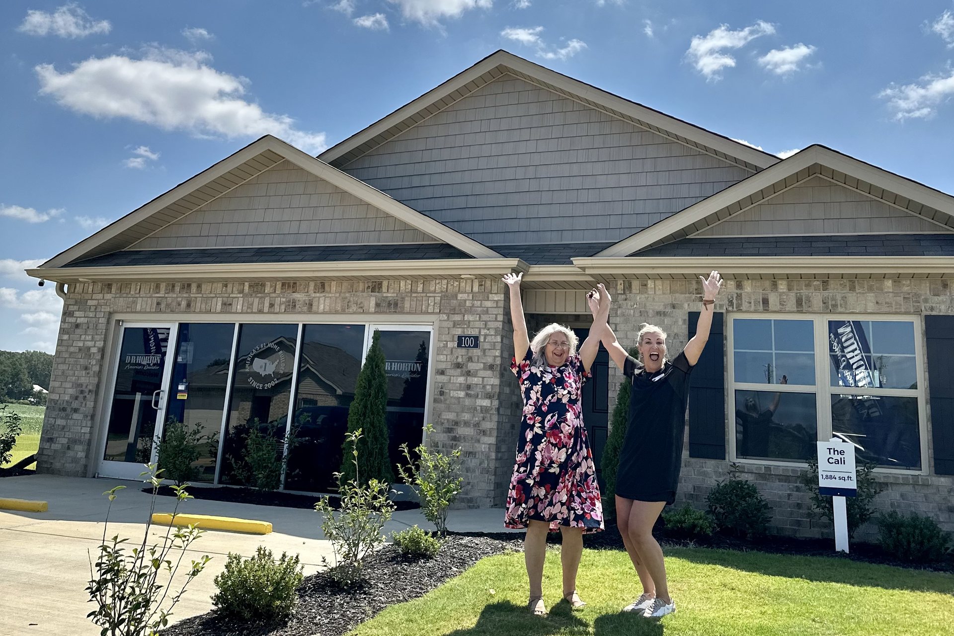 Sallye Elliott celebrating with a client outside a newly purchased home